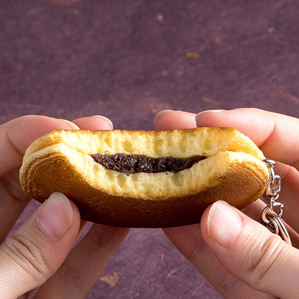 これは元祖食品サンプル屋の「キーリング かじったどら焼き」の手で持った商品イメージ画像です。