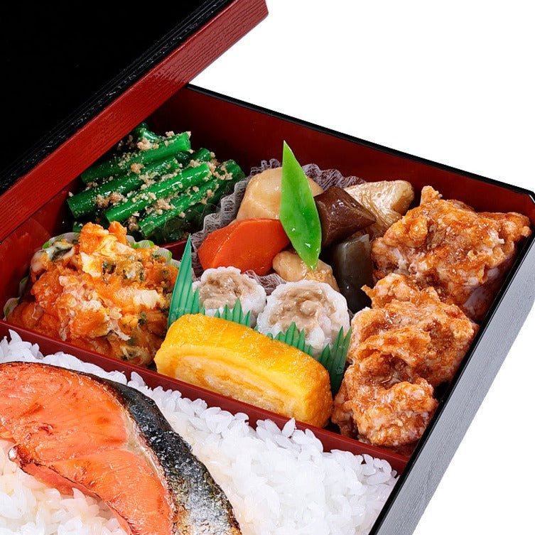 オリジナル食品サンプル「鮭弁当」の商品画像です。おかずは、唐揚げ、カボチャのサラダ、インゲンの白和、煮物、しゅうまい、卵焼きが入っています。