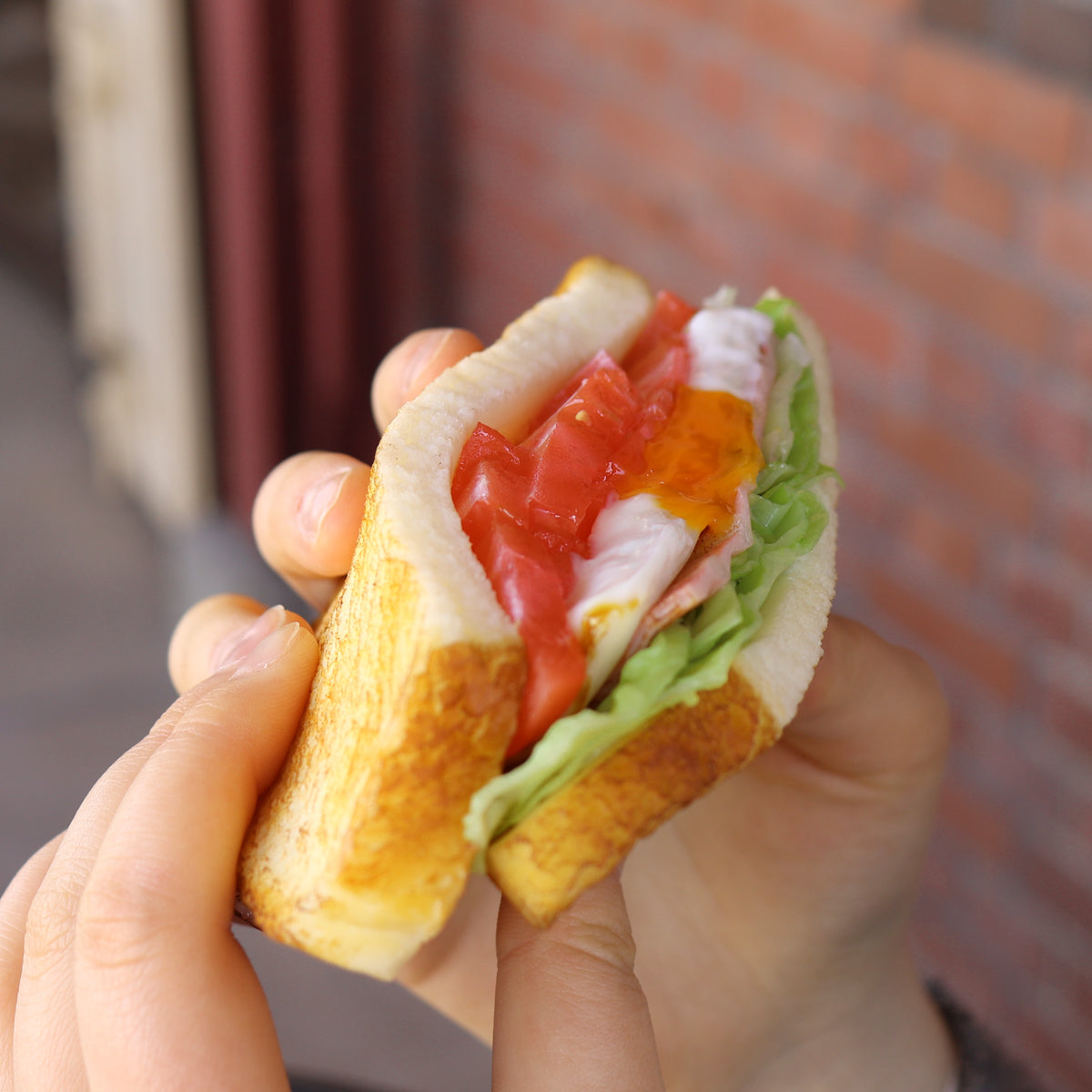 これは元祖食品サンプル屋の「ホットサンド」の手で持った商品イメージ画像です。