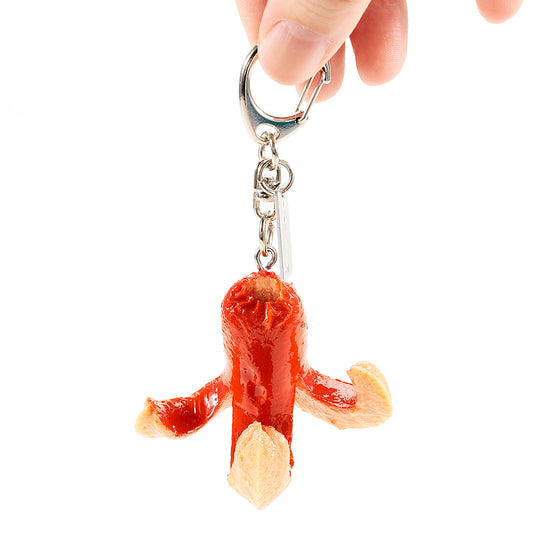 食品サンプル「たこさんウインナー キーリング」を手で持っている様子。赤いウインナーのツヤ感や、開いた足先まで細かく表現した、かわいいfake foodキーホルダー。
