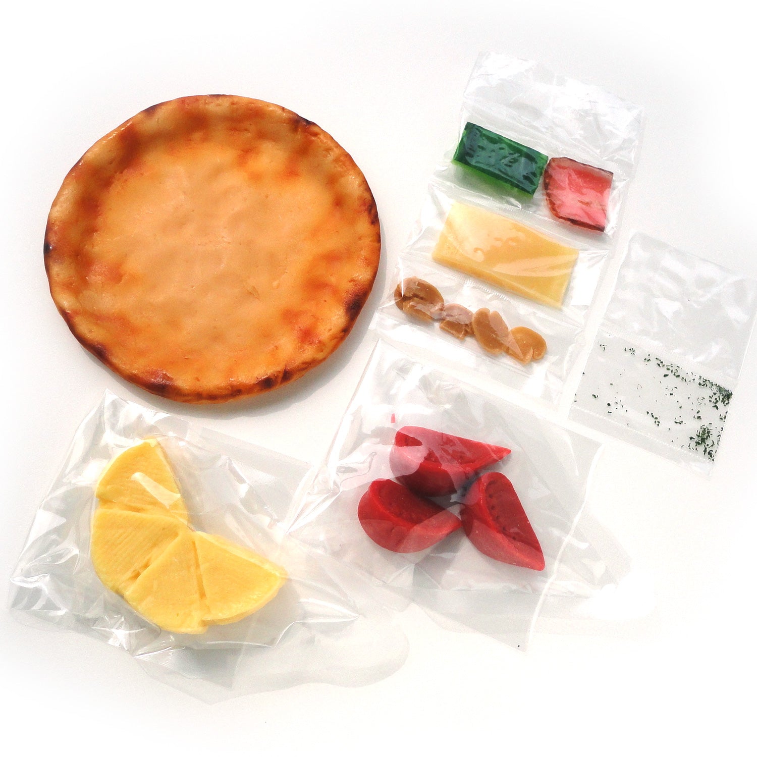 自分でつくる食品サンプル製作キット「さんぷるんvol.2 ミックスピザ」の内容物の画像です。