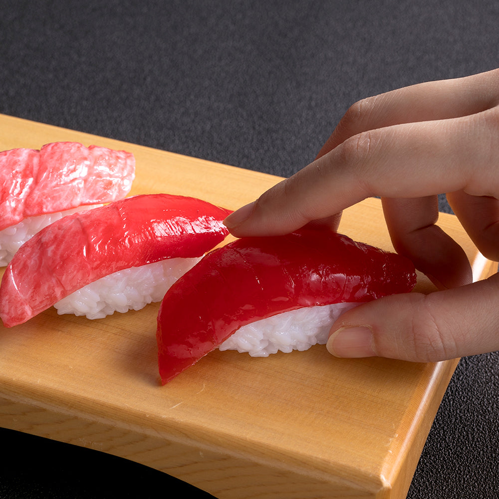 これは食品サンプル屋の「マグネット 寿司」の指でつまんだ商品イメージ画像です。