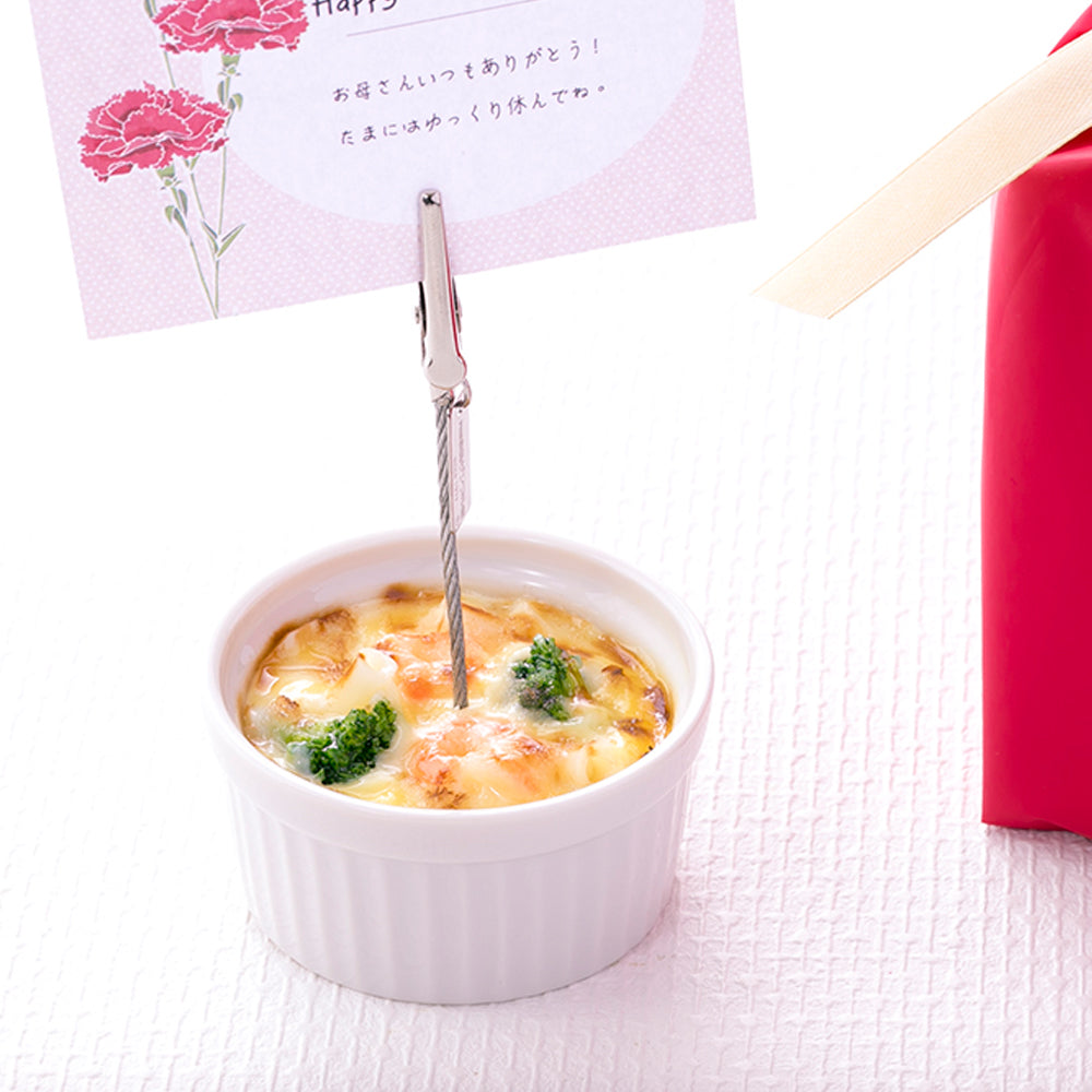 これは元祖食品サンプル屋の「グラタン クリップ」のメッセージカードを挟んだ商品使用イメージ画像です。