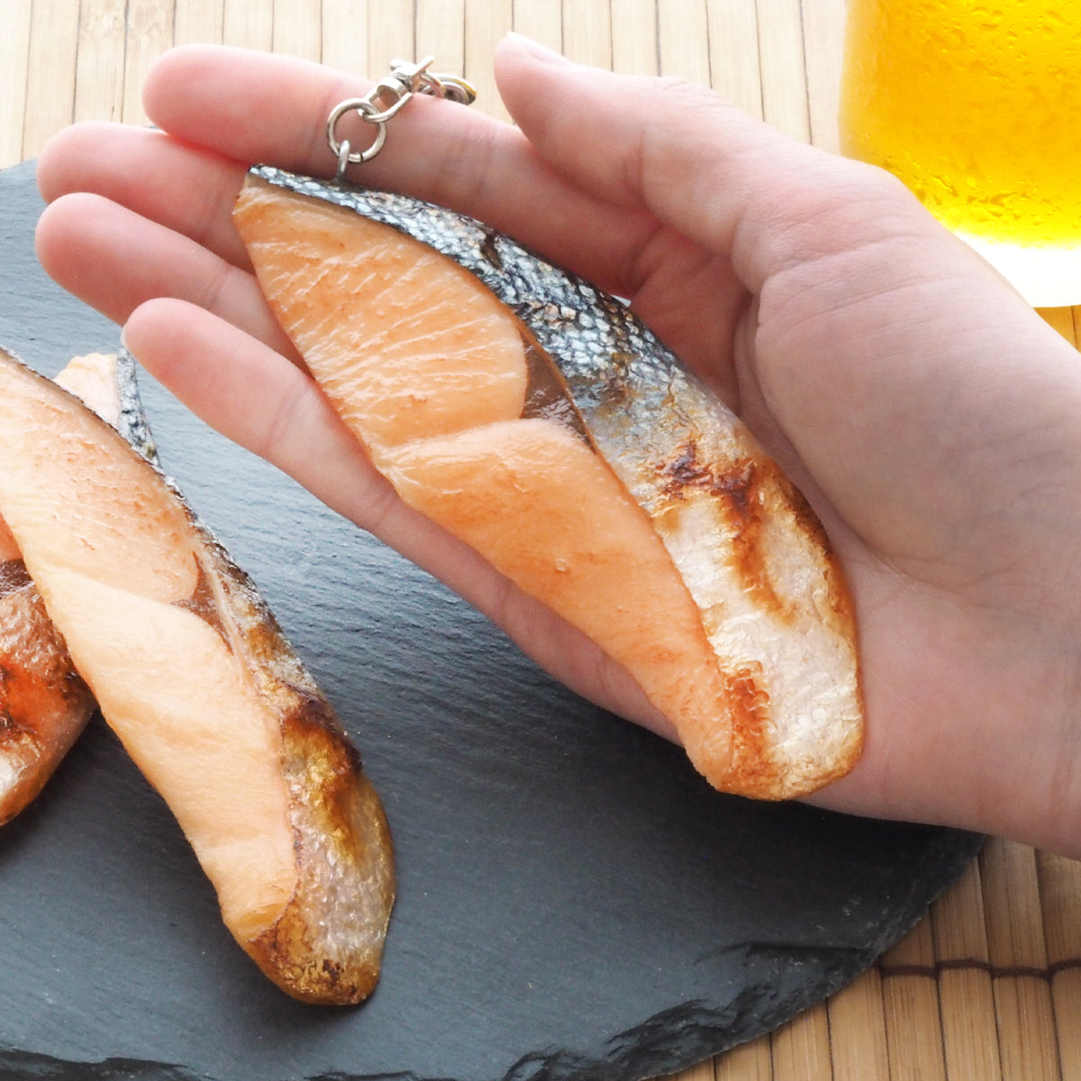 これは元祖食品サンプル屋「キーリング 焼魚鮭(中)」の手にのせた商品イメージ画像です。