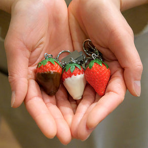 これは元祖食品サンプル屋の「キーリング イチゴ ミルクチョコ」の手のひらにのせた商品イメージ画像です。
